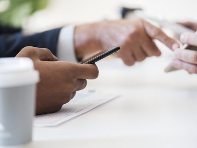 closeup-businessmen-using-mobile-phone-min